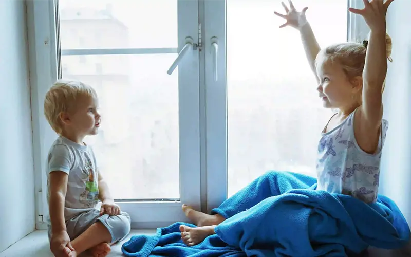 Um menino e uma menina olhando-se de frente com sorrisos nos rostos.