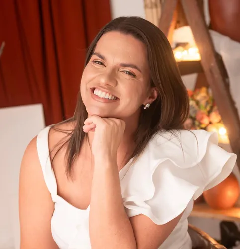 mulher de roupa branca com a mão no queixo