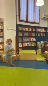 menina correndo numa biblioteca com seu livro