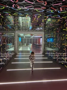 menina andando num corredor com luzes