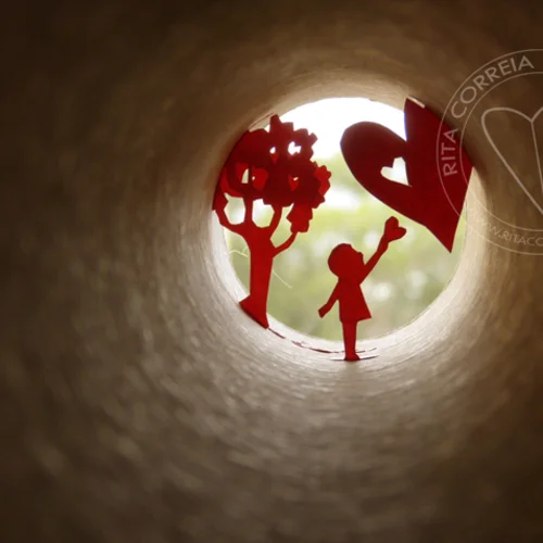 arte em tubo com desenhos em vermelho imitando uma criança, uma árvore e um coração