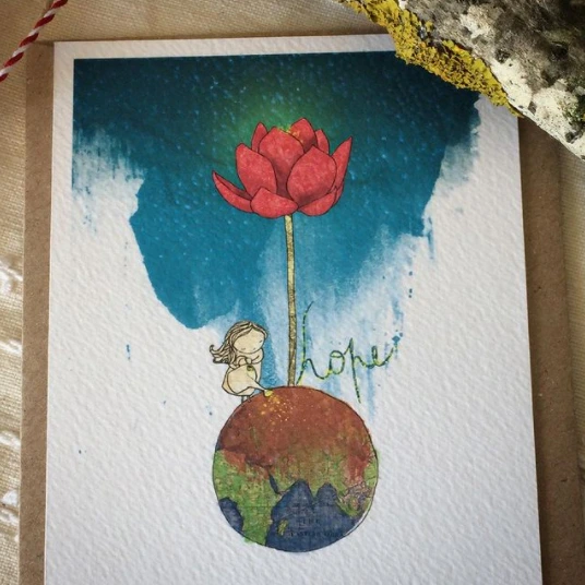 desenho em aquarela, onde uma menina e uma rosa aparecem em cima do mundo. A palavra "hope" está em destaque